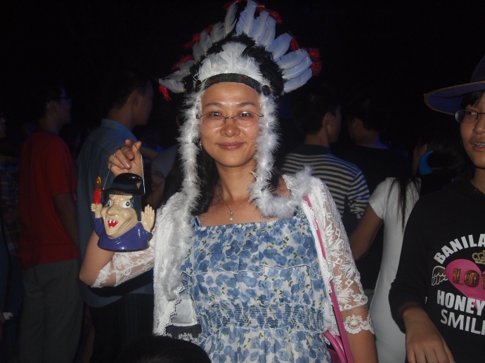 Random student in a flowery dress and white feathered Indian headdress