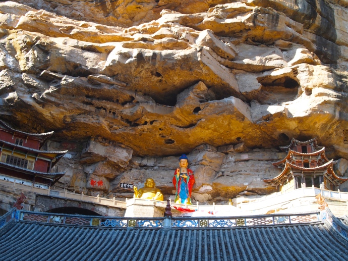 New statues of Guanyin and Maitreya, the smiling Buddha, on the cliff ledges at Baoxiang Temple